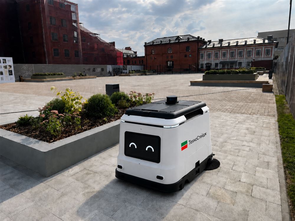 Белый робот VacoRobot с логотипом Техностейдж на площади